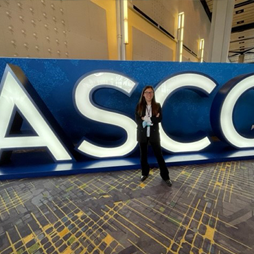 Female event planner standing in front of ASCO entrance sign | Global Agency. BCD Meetings & Events 