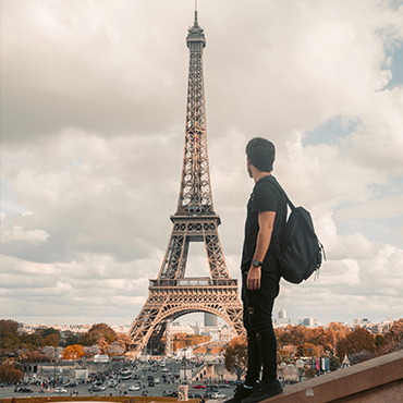 Bleisure traveler in front of the Eiffel Tower for a meeting and event in Paris | Global Agency BCD Meetings & Events