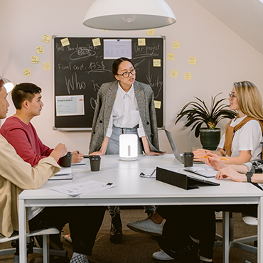 Four meeting planners having a meeting around a desk | Global Agency. BCD Meetings & Events