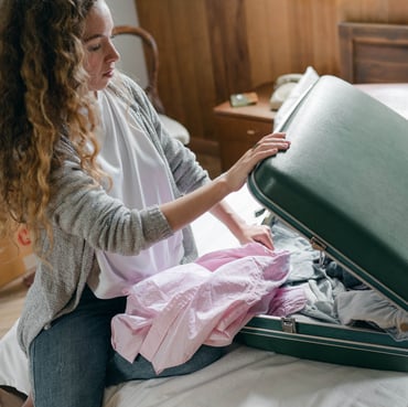 Female bleisure traveller packing her suitcase with clothes for a meeting or event. | Global Agency BCD Meetings & Events